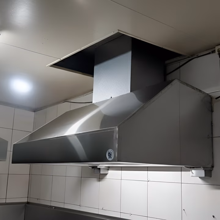 Campana extractora tradicional de acero inoxidable instalada en una cocina