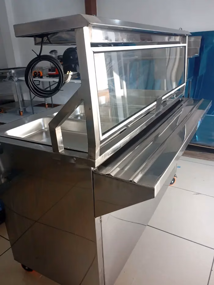 Mesa térmica de acero inoxidable con vidrio protector y rodos