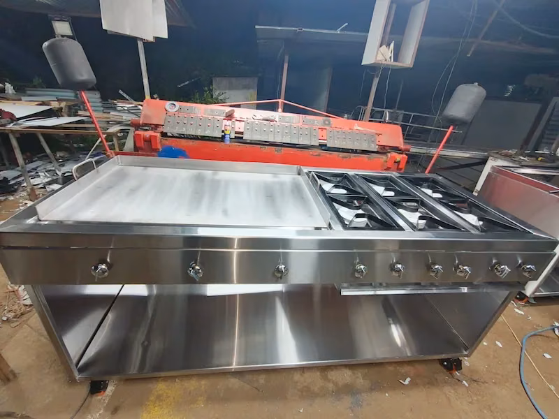 Plancha de acero inoxidable con quemadores en el taller de Grupo Dov, junto a la maquinaria de trabajo